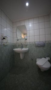 Un baño con lavabo, inodoro y espejo. en Green House Apart Hotel, en Gümbet 5 fotos más