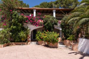 Una casa con flores al costado. en 2BR Ground-Floor Villa Apartment with Pool, 10mins drive to Ibiza Airport, en Sant Josep de sa Talaia