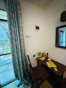 a room with a desk and a table and a window at Budget dorm in Paje for 4 people in Paje