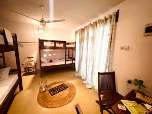 a living room with a table and a bed at Budget dorm in Paje for 4 people in Paje