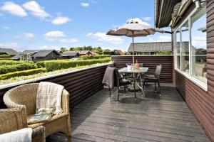 une terrasse avec une table, des chaises et un parasol dans l'établissement 40384-Juelsminde-Frede-Juels-Vej-274, à Sønderby