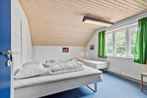 two beds in a room with green curtains at C11605-Olgod-Herningvej-10 in Ølgod