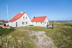 a white house with a red roof on top of a field at JB150-Frostrup-Strandkaervej-18 in Lild Strand +17 photos