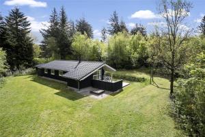 una piccola casa nera in mezzo a un campo di JB243-Fjerritslev-Aspevej-1 a Fjerritslev