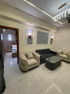 a living room with couches and a couch and a table at Premium 2BHK Stay Spacious Stylish in Noida in Noida
