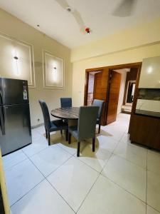 a kitchen and dining room with a table and chairs at Premium 2BHK Stay Spacious Stylish in Noida in Noida