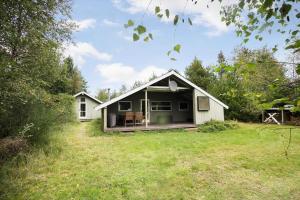 a small white house with a porch on a field at JB329-Brovst-Egernvej-29 in Bratbjerg