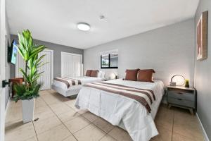 a bedroom with two beds and a plant in it at 5BR Game Retreat Pool, Mini Golf and Firepit L86 