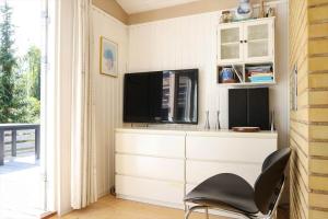a living room with a tv and a chair at 13356-1-Hojby-Harpevej-32 in Gudmindrup