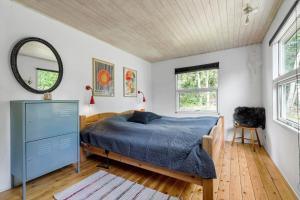 - une chambre avec un lit, un miroir et une commode dans l'établissement 8869-Glesborg-Fuglevaenget-3, à Fjellerup