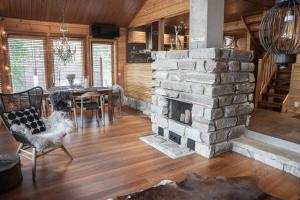 a living room with a stone fireplace and a table at Villa Mocca in Levi - Lapnest in Kittilä