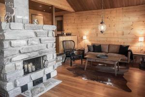 a living room with a stone fireplace and a couch at Villa Mocca in Levi - Lapnest in Kittilä