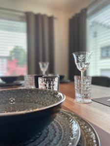 a wooden table with a plate and glasses on it at Ferienwohnung Nostalgic In der Nähe von Sinsheim Apartmenthaus Traudl in Zuzenhausen