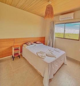 a bedroom with a bed and a window and a chair at Ap superior Amanita Kite Home - vista mar piscina in Ponta do Anel +19 photos
