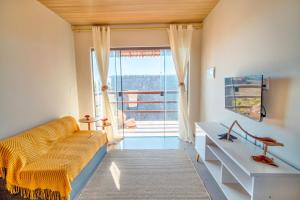 a living room with a couch and a large window at Ap superior Amanita Kite Home - vista mar piscina in Ponta do Anel