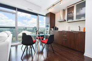 トロントにあるDowntown Toronto Condo CN Towerのキッチン(ガラステーブル、黒い椅子付)
