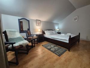 a bedroom with a bed and a mirror and a chair at Vila Poiana Verde in Slănic-Moldova