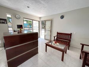 a living room with a counter and a bench and a table at HOTEL VILLA CALAKMUL in Xpujil