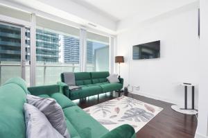 トロントにあるDowntown Toronto Condo CN Towerの緑のソファとテレビのあるリビングルーム +10枚の写真