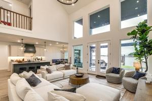 a living room with white furniture and a kitchen at Dock and Hot Tub! High-End Cedar Creek Lake Retreat in Gun Barrel City