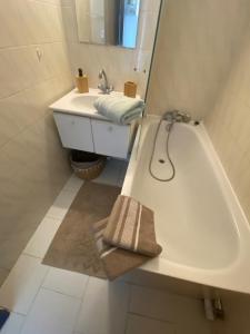 ein Badezimmer mit Badewanne, Waschbecken und Spiegel in der Unterkunft L' instant Bohème T2 clim , piscine , parking in Balaruc-les-Bains