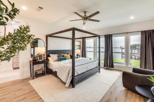 a bedroom with a canopy bed and windows at Dock and Hot Tub! High-End Cedar Creek Lake Retreat in Gun Barrel City