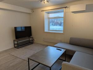 a living room with a couch and a television at Modern apartment near train station H77A in Narvik +59 photos