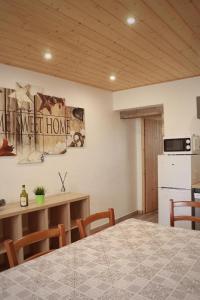 a kitchen and dining room with a table and a refrigerator at O brame du cerf - logement avec sauna in Charchilla