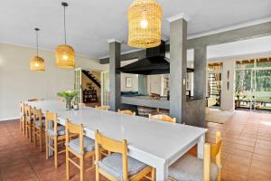 een eetkamer met een grote witte tafel en stoelen bij Farmhouse in Kaapstad