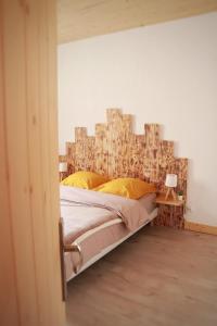 a bedroom with a large bed with a wooden headboard at O brame du cerf - logement avec sauna in Charchilla