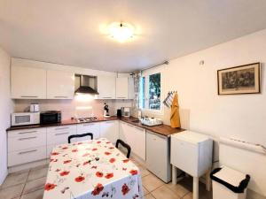 Gîte de France Le noyer 2 épis - Gîte de France 2 personnes MAE-9474 في Saint-Germain-les-Vergnes: مطبخ مع طاولة وطاولة وكراسي