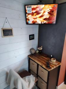 a room with a desk and a tv on the wall at La cabane zen in Saint-Martin-des-Champs