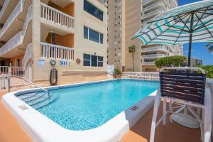a swimming pool with an umbrella next to a building at atlantic terrace pompano beach #1 in Pompano Beach