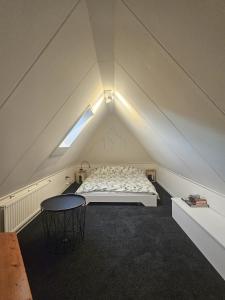 a attic bedroom with a bed and a table at Appartement "de grote Vesting" Elburg in Elburg