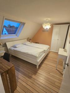 a bedroom with a white bed and a window at Appartement "de grote Vesting" Elburg in Elburg +12 photos