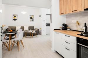 a kitchen and living room with a table and chairs at NeoLoft 1st in Popeşti-Leordeni