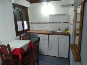 Una pequeña cocina con una mesa y un fregadero. en Hostería El Bosque, en Villa Gesell 32 fotos más
