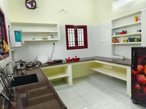 a kitchen with green and white counters and a sink at Ecstasy Homestay Puducherry in Pondicherry
