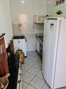 a kitchen with a white refrigerator and a microwave at Casa Pequena e agradável em Ilhéus in Ilhéus