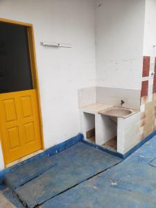 a room with a yellow door and a sink at Casa Pequena e agradável em Ilhéus in Ilhéus +8 photos