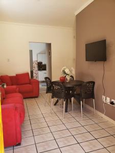 a living room with a red couch and a table at Casa Pequena e agradável em Ilhéus in Ilhéus