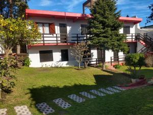 a house with a garden in front of it at Hostería El Bosque in Villa Gesell +25 photos