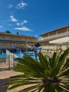 a resort with a palm tree in front of a building at Sun Galicia Hotel y Apartamentos in Sanxenxo