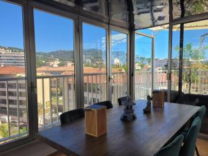 a large room with a wooden table and large windows at Rooftop apartment Cannes center - Parking in Cannes