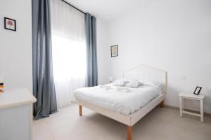 Un dormitorio blanco con una cama blanca y una ventana. en Rose of pyramid, en Roma