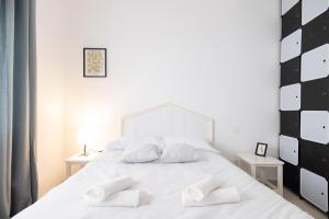 Un dormitorio con una cama blanca con dos almohadas blancas. en Rose of pyramid, en Roma 1 foto más