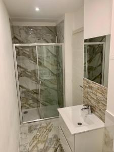 a white bathroom with a shower and a sink at 1 BEDROOM APARTMENT iN ViLLA MATEKA in Roquebrune-Cap-Martin