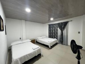 una camera da letto con due letti e una finestra di Habitación en casa campestre con piscina a Villavicencio