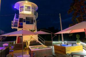 a lighthouse at night with tables and umbrellas at Hotel Bahia Del Faro in Guatapé