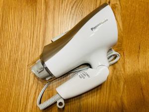 - une télécommande assise au-dessus d'une table en bois dans l'établissement Shirakaba no mori Cottage - Vacation STAY 60815v, à Abashiri